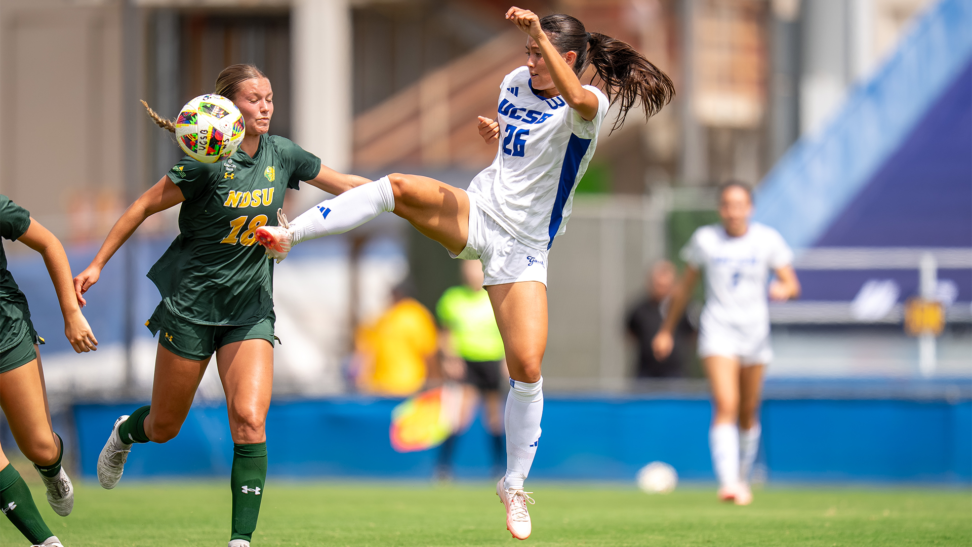 Avery Standish (#26) jumps to kick a ball out of mid air before a North Dakota State defender comes in to head it.