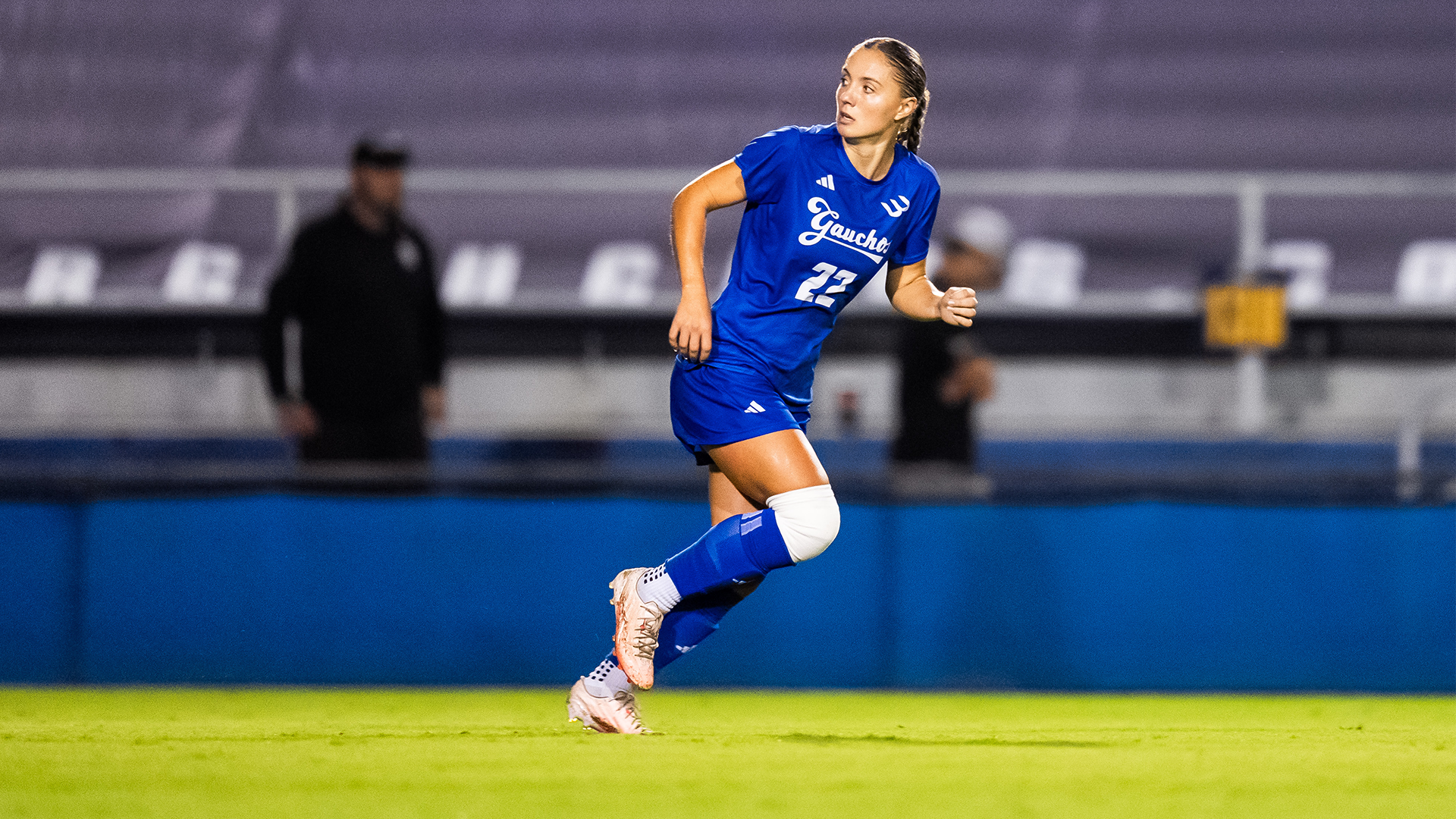 Emily Caughey runs while looking at a goal kick.