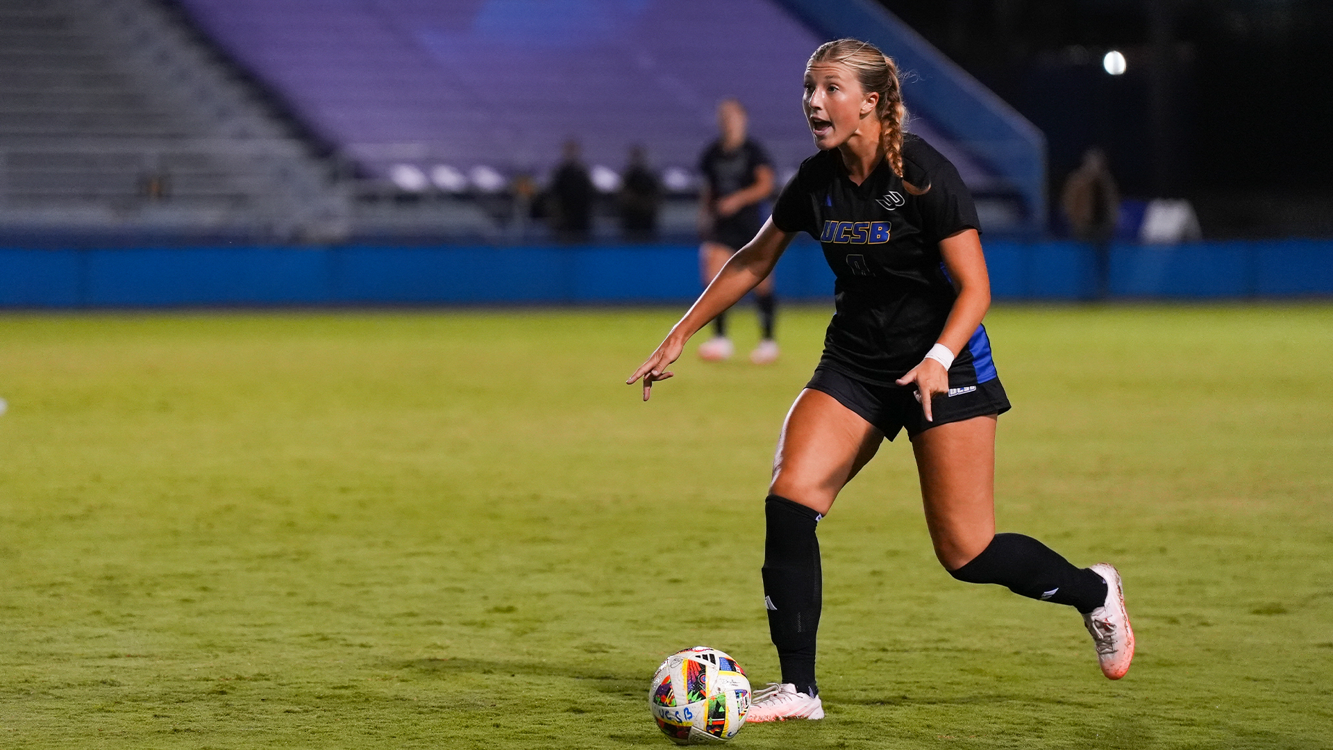 Regan Stiner (#8) directs the Gaucho build while passing the ball from the backline. 