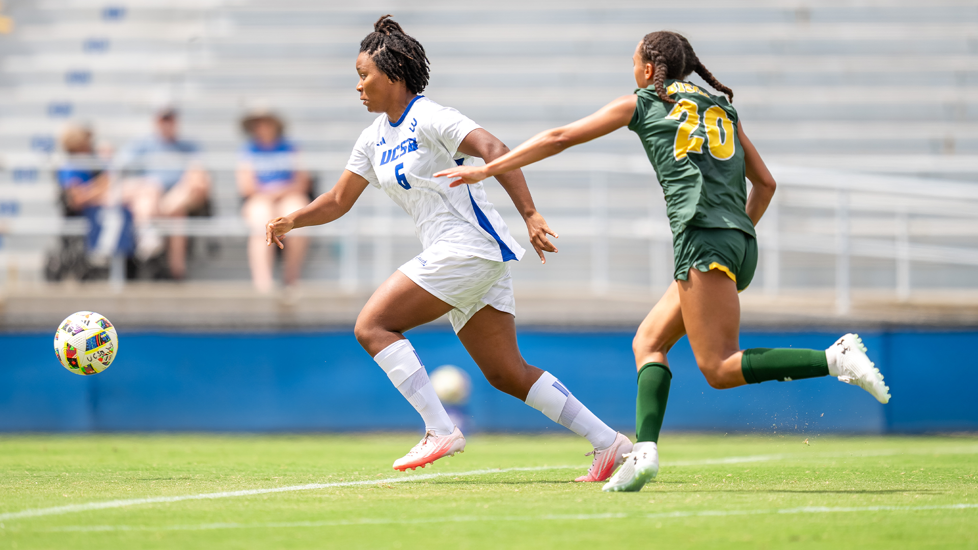 Devin Greer (#6) reacts toward a bouncing soccer ball as a defender chases her.