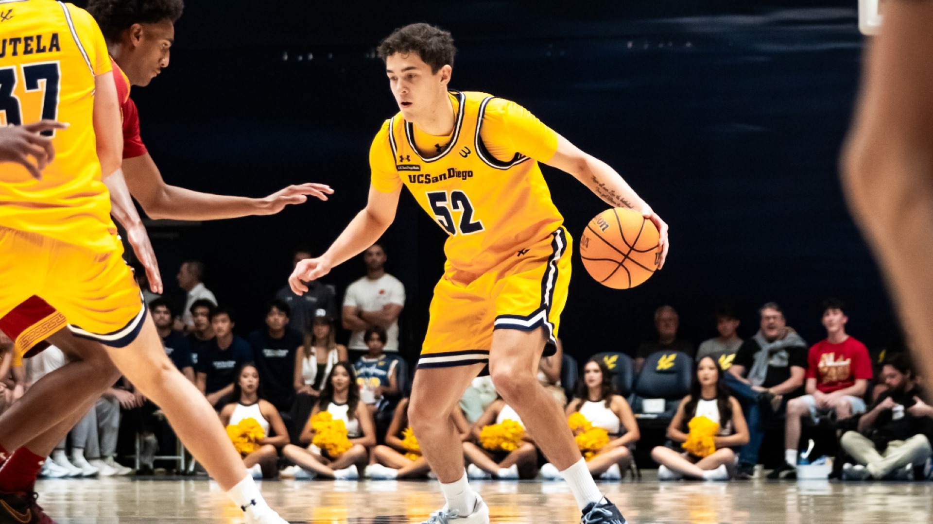 Treysen Eaglestaff from UC San Diego dribbles the basketball in an exhibition game against USC
