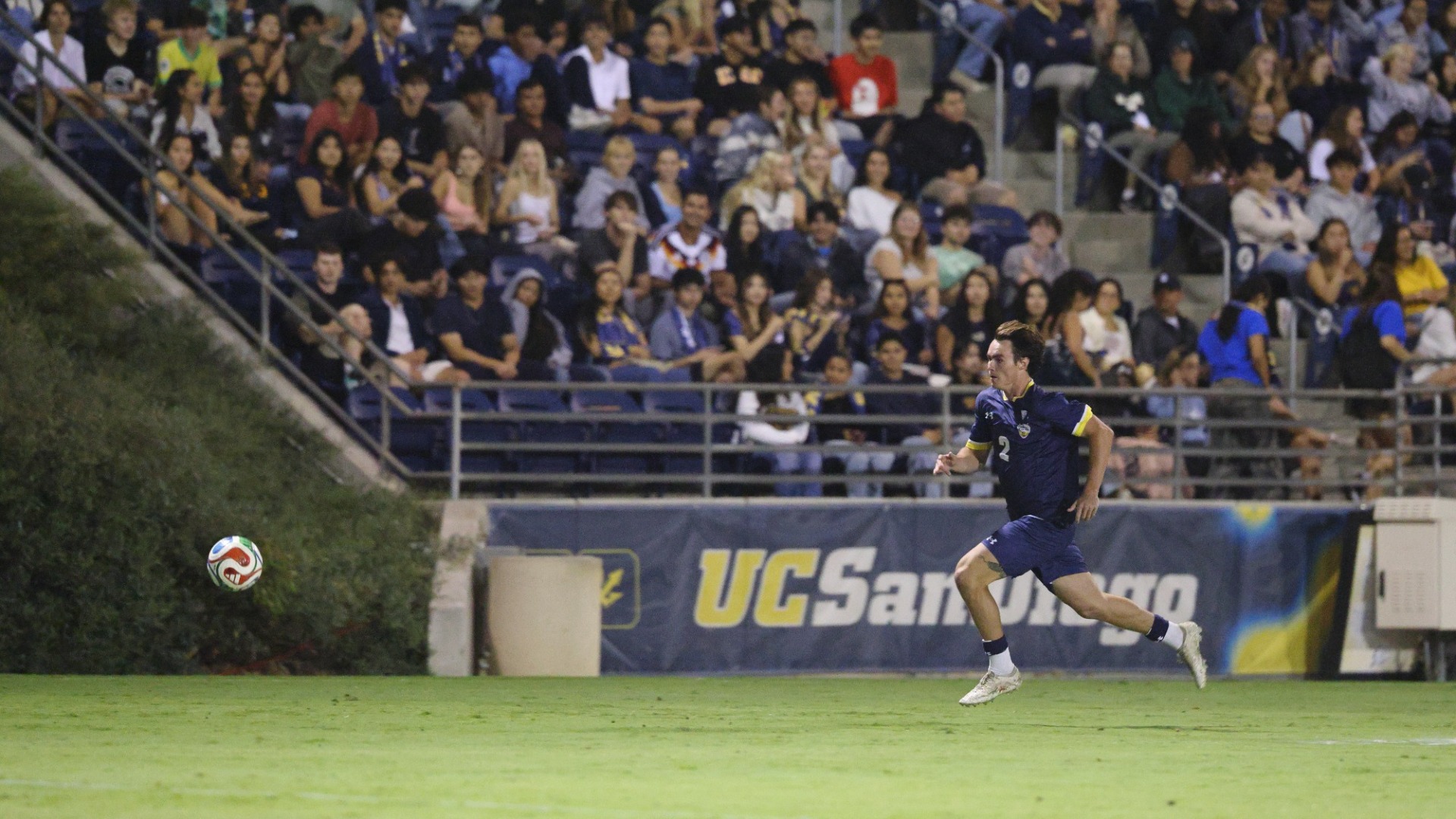 Matias Mott running after a ball in front of full stands at Triton Soccer Stadium