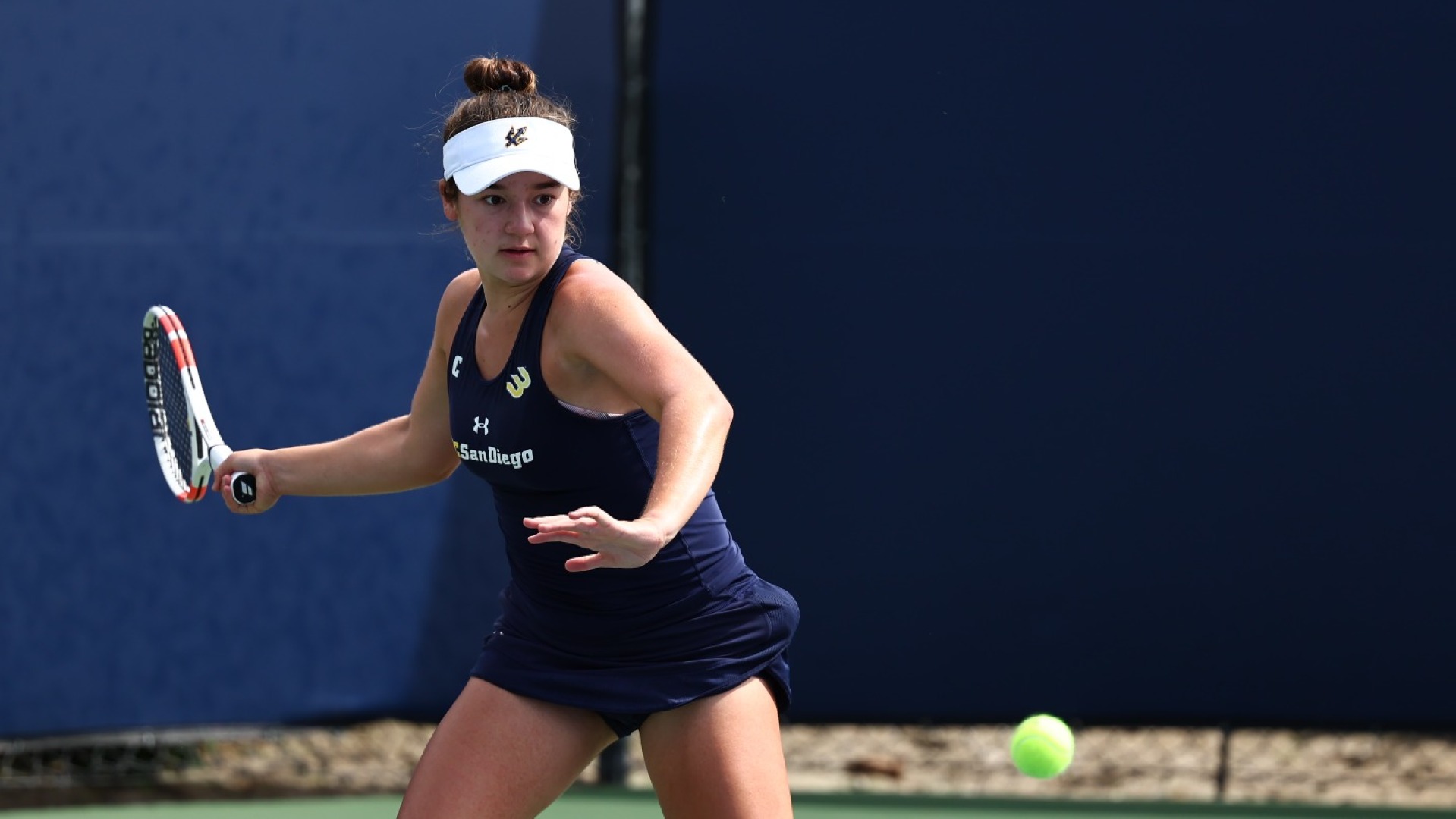 Olivia Allegre prepares to hit a return shot with the tennis ball in frame