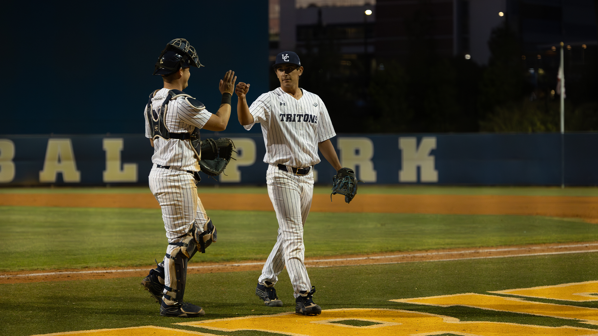 Drake Bicknell and Nathan Ries high five as they walk off the field