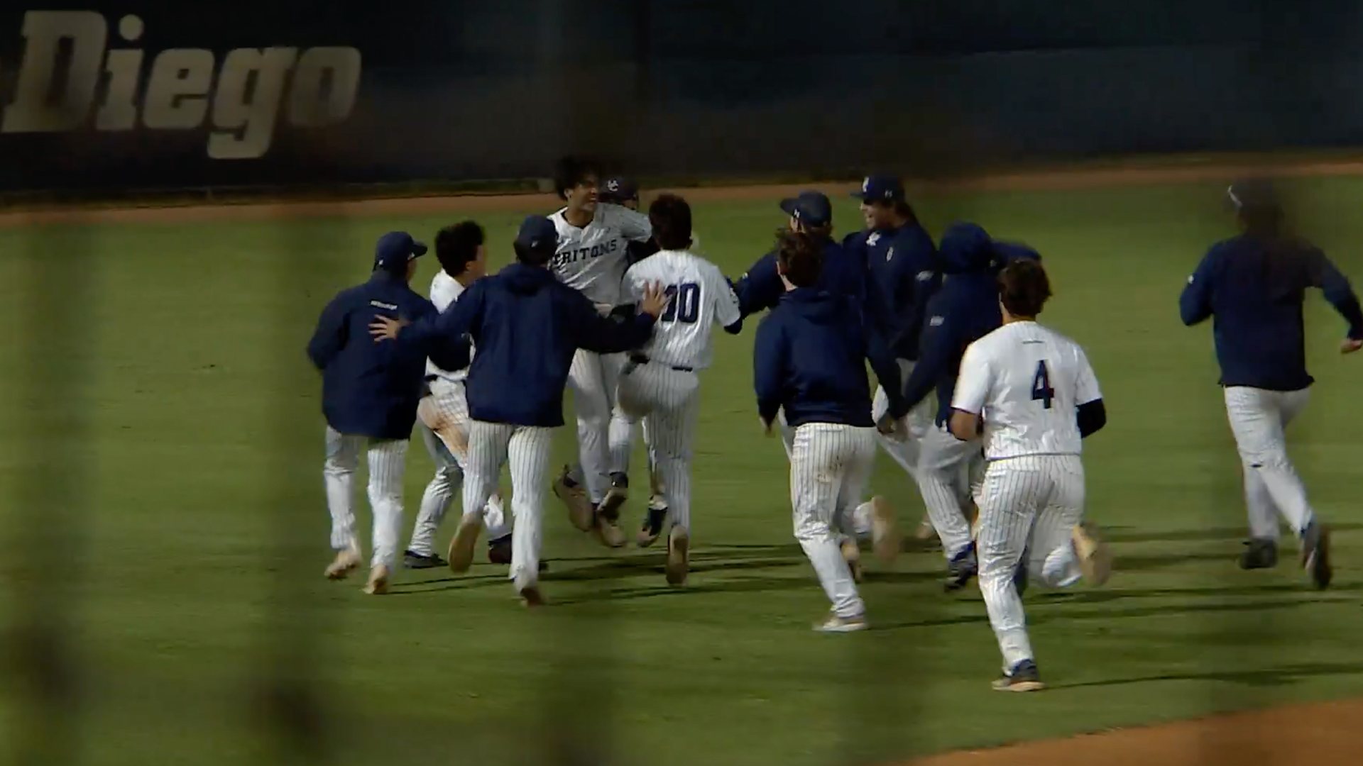 Nathaniel Widelski celebrates with team on field vs Fullerton