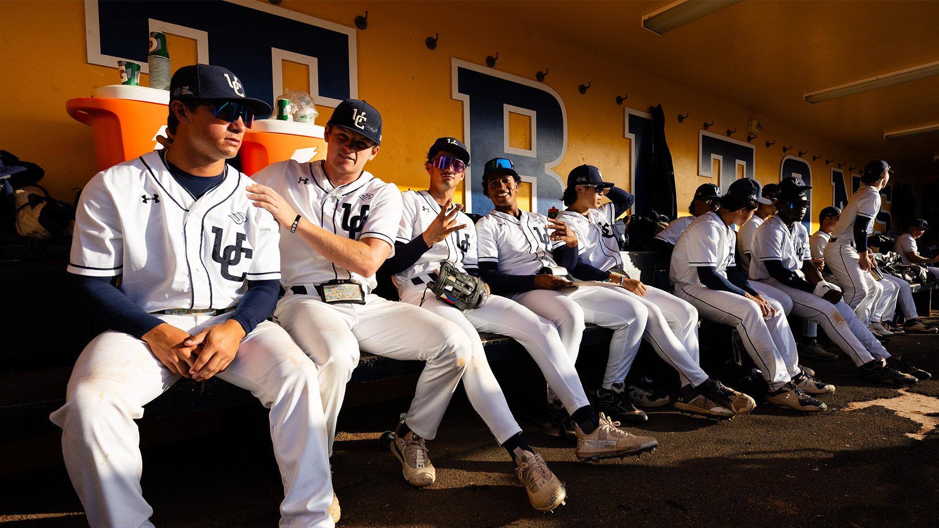 Baseball players pose in dugout