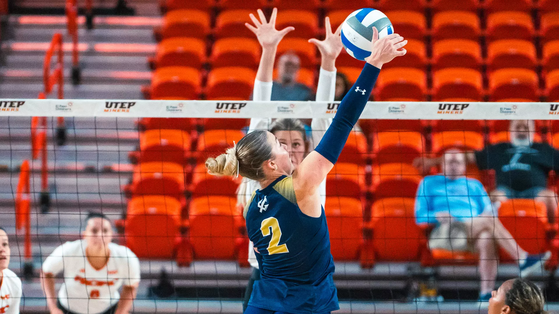 Ireland McNees hits ball over the net at opponent blocker