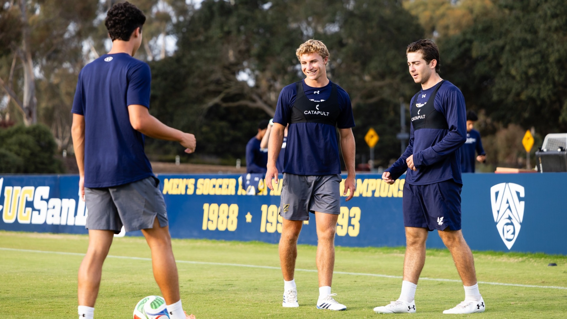 Men's Soccer players warming up with a Pac-12 logo in the background