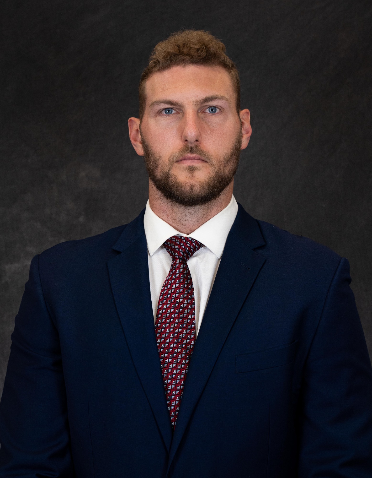 A portrait photo of men's basketball assistant coach Sean Damaska taken in the summer of 2024 