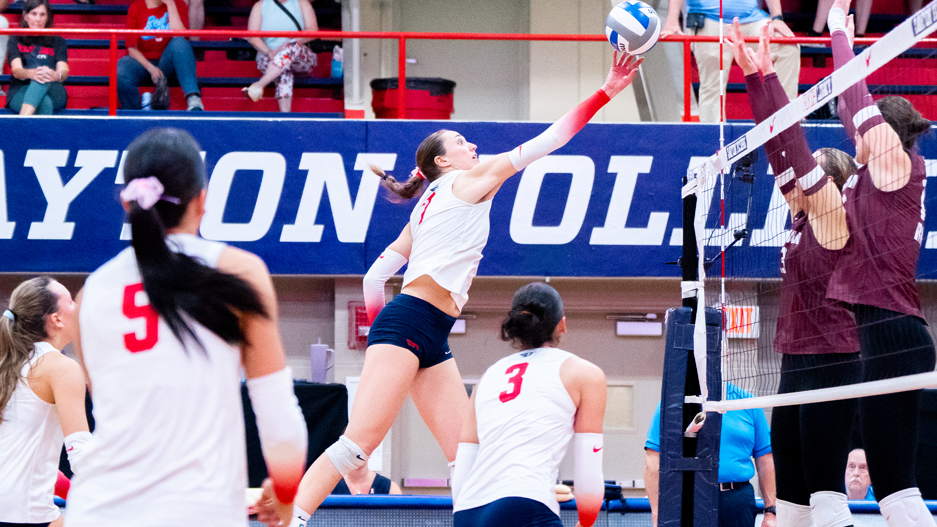 Kaitlyn McNeel is in the air, attacking the ball with her right hand.