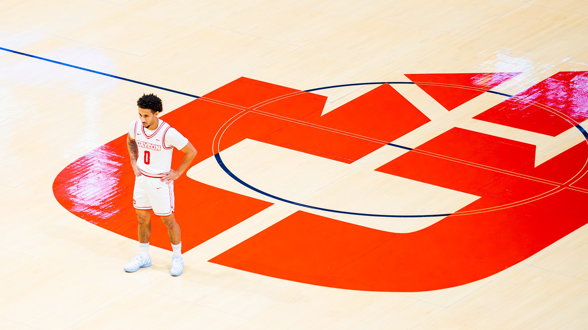 Dayton men's basketball player Javon Bennett stands at midcourt of a game wearing his white jersey.