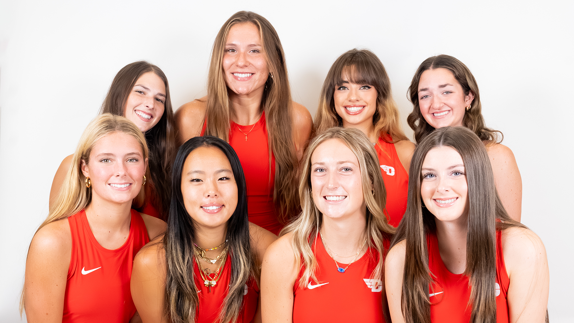 The 2025-26 women's tennis team poses for a photo in front of a white background. The team is in matching red uniforms.