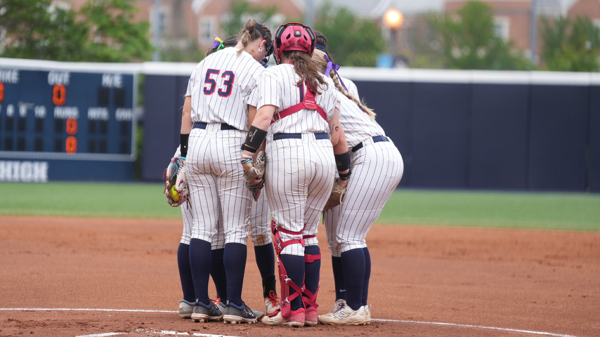 Members of the softball team huddle together in the circle prior to the start of an inning at GW Softball Field during the Atlantic 10 Championship