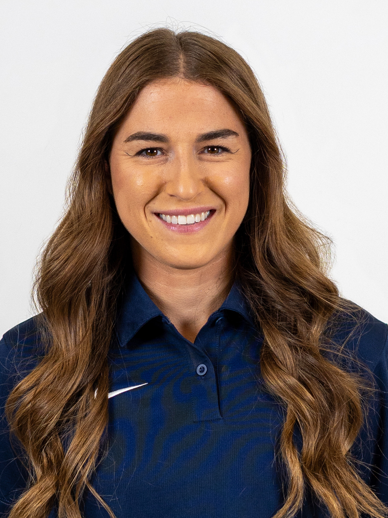 Portrait image of women's golf head coach Ellie Sipe wearing a blue polo-stye shirt