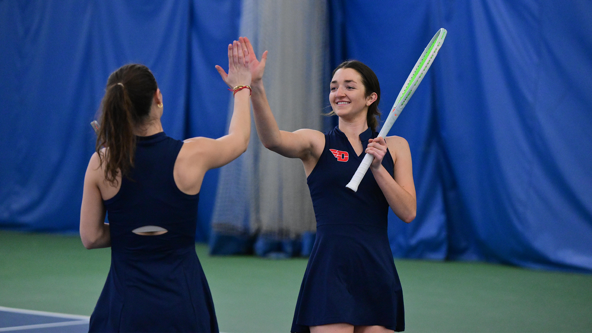 Haley Klein and Grace Murphy high five. Murphy's back is to the camera