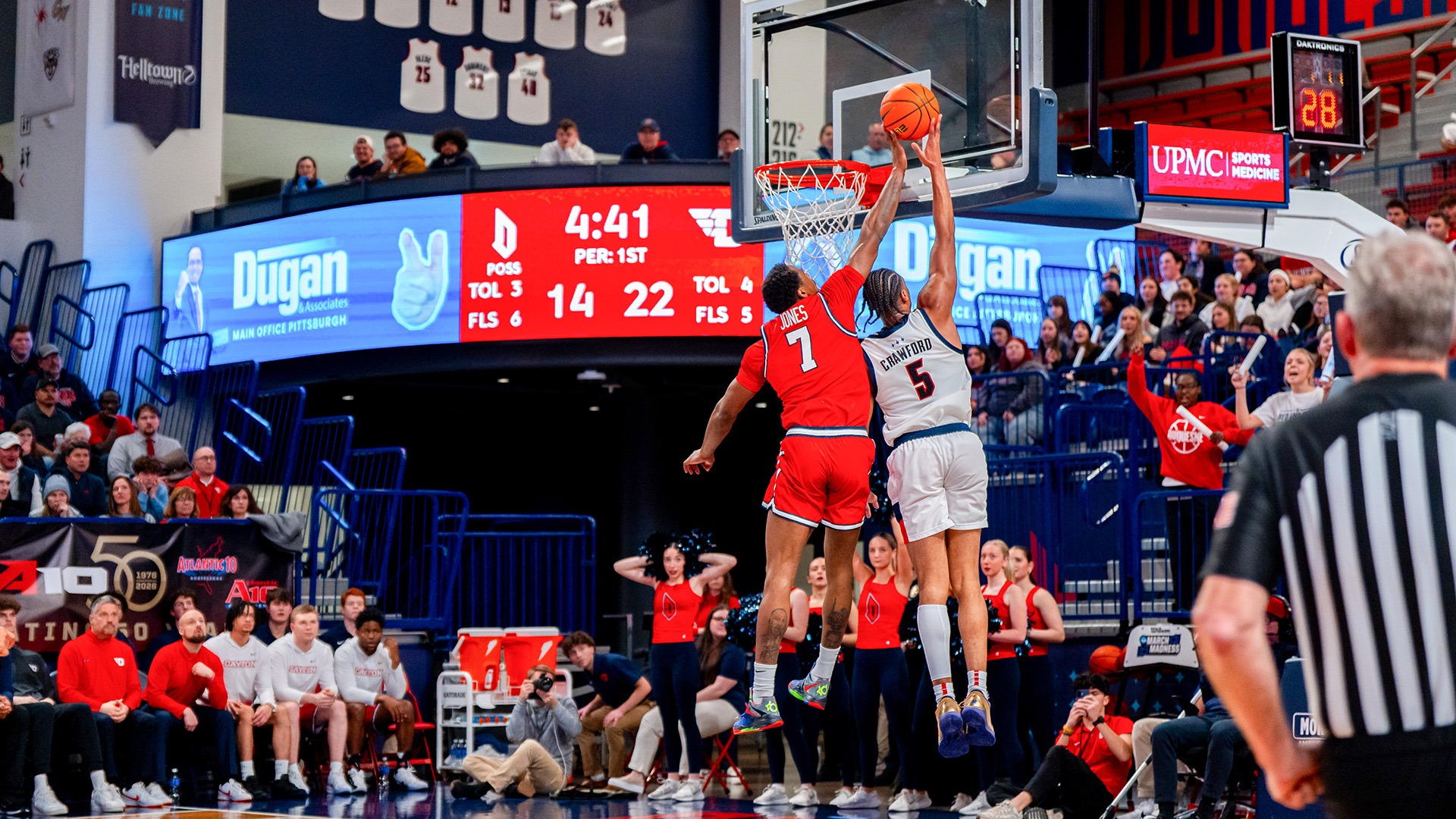 Dayton men's basketball player Keonte Jones swats a Duquesne from behind, with the ball just above the hoop. 