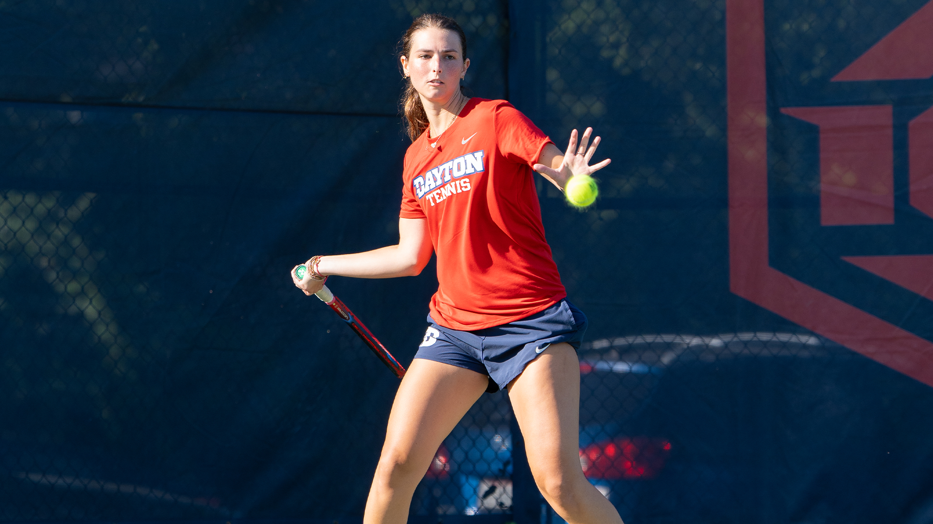 Grace Murphy swings her racquet at a tennis ball.