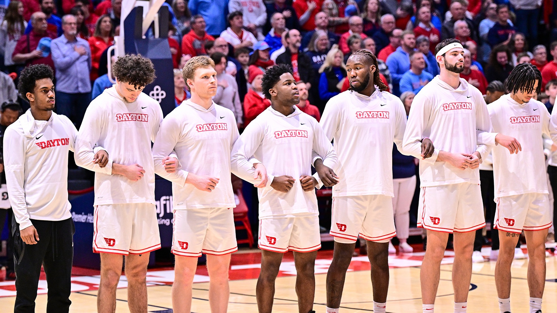 Dayton men's basketball players locked in arms during the National Anthem.