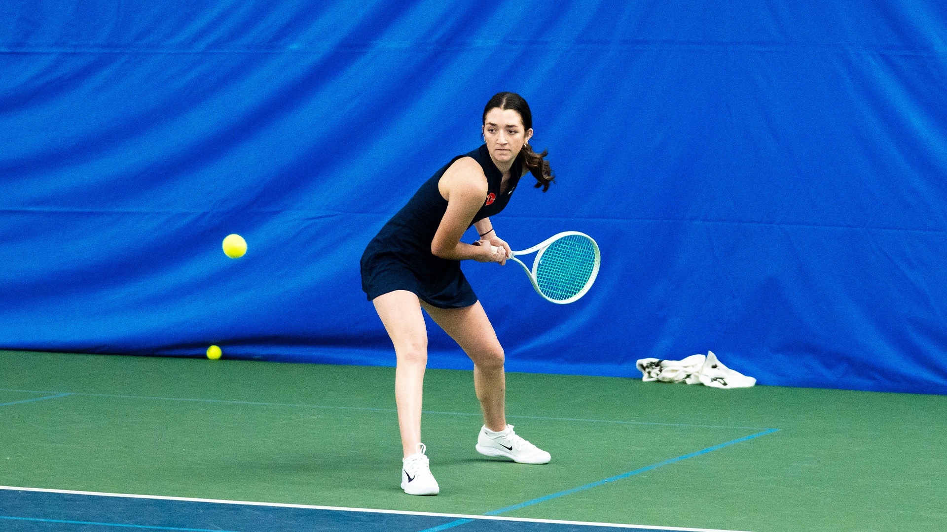 Haley Klein winds up her racquet down low to hit the ball coming towards her.