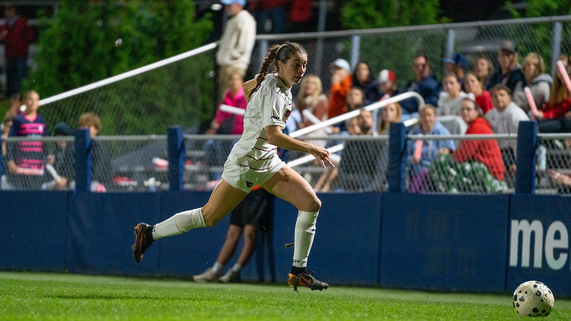 Dayton women's soccer player Liv Grenda dribbles the ball wearing a white Dayton Flyers uniform.