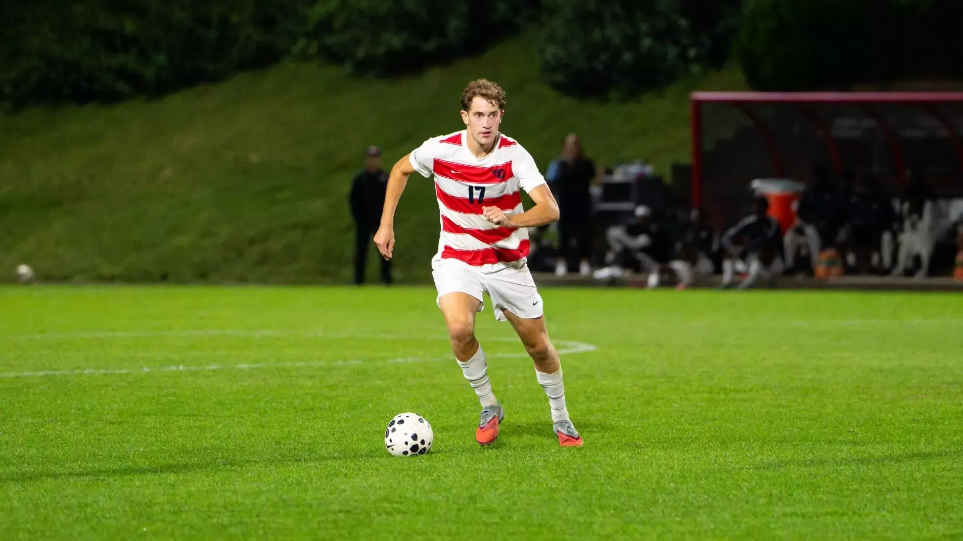 Bonham dribbles down field against VCU wearing Dayton's white uniform with red stripes
