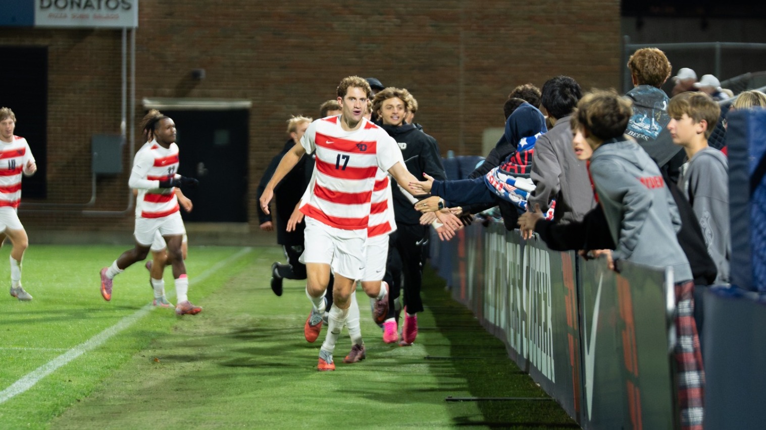 Miles Bonham high fiving fans after a win vs Fordham