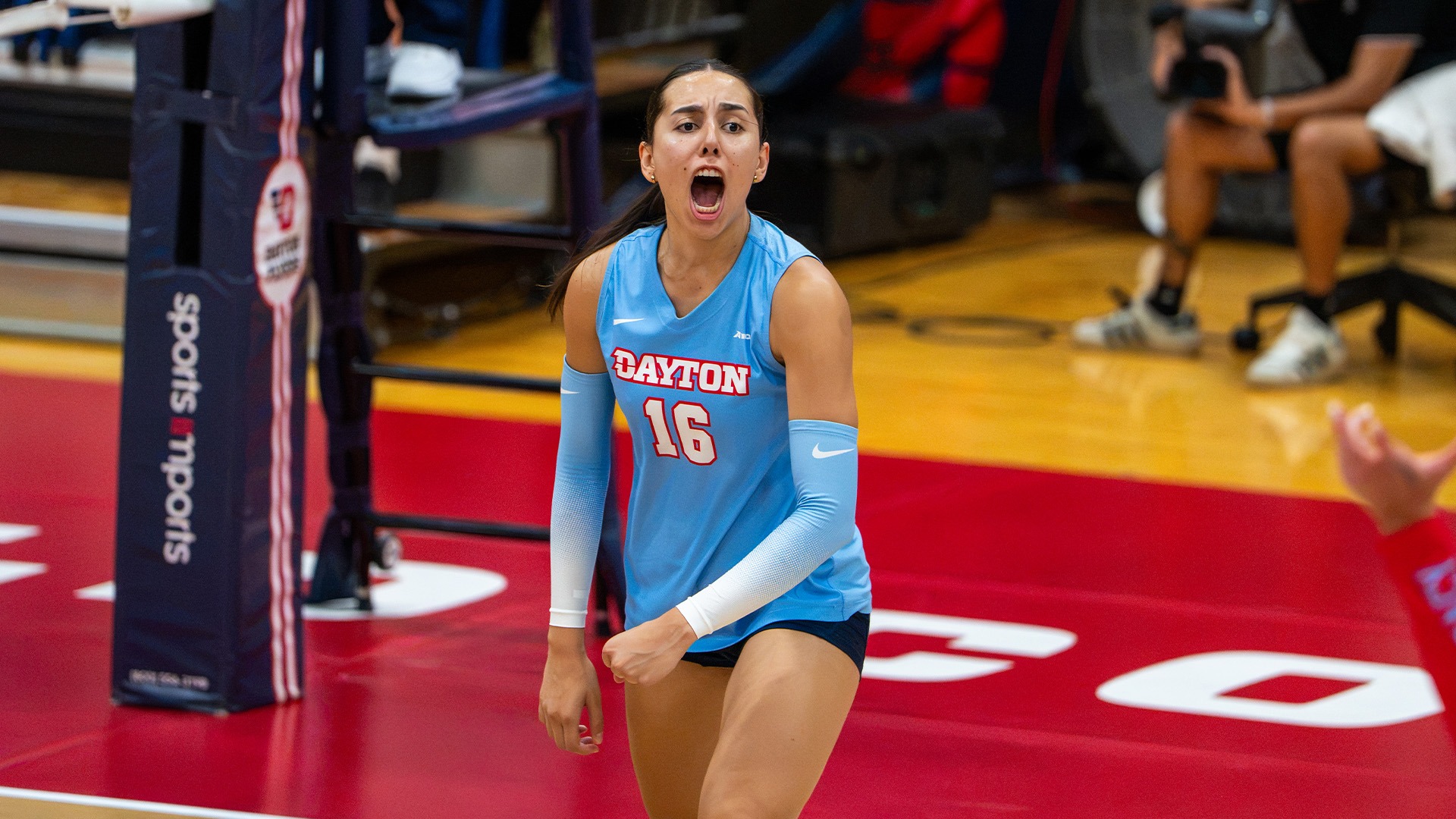 Gabriela Machin Borges balls up her fists and yells in celebration after a point. She is wearing a chapel blue jersey.