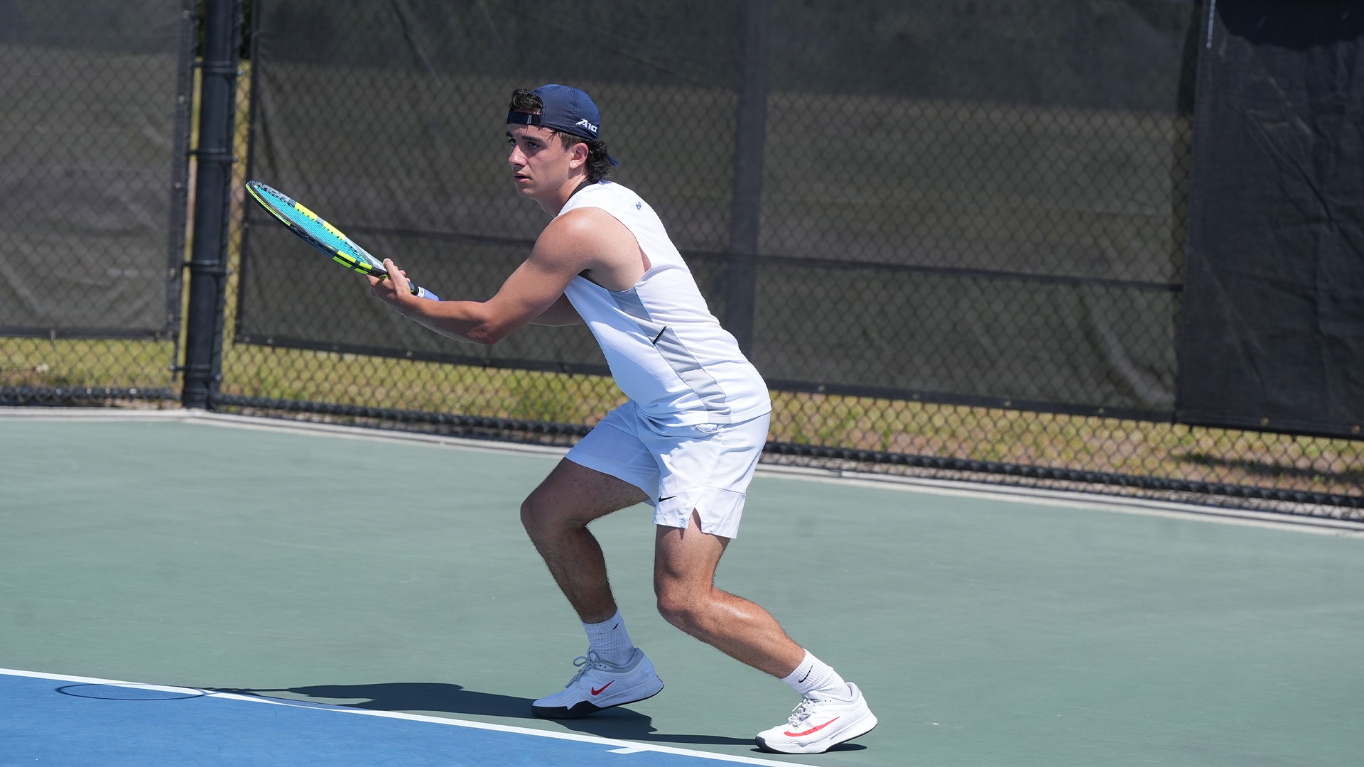 Dylan Jaen holds onto his racquet in both hands to receive the serve.