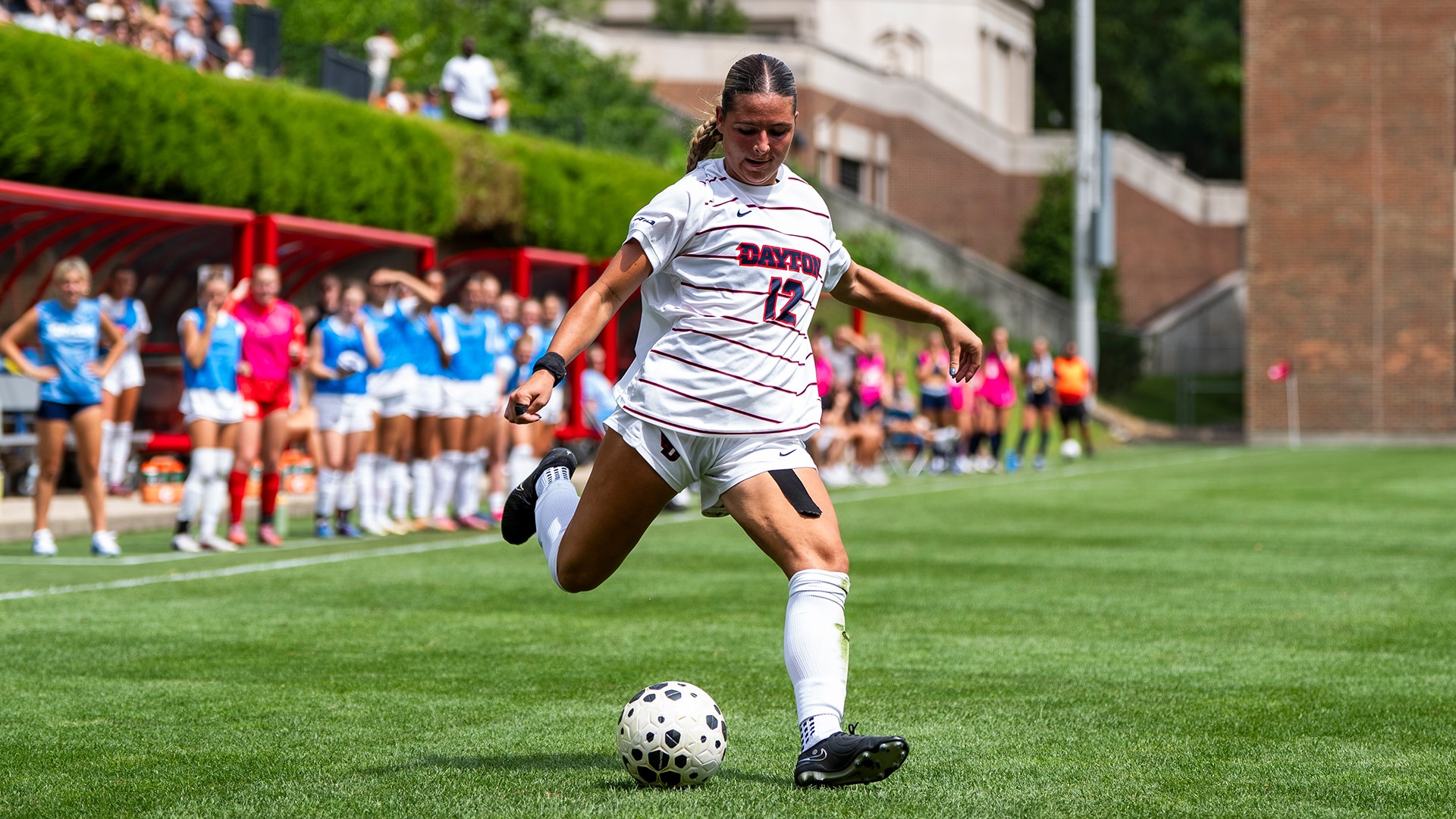 Dayton women's soccer player Lauryn Contini, wearing a white Dayton jersey, attempts to kick a ball.