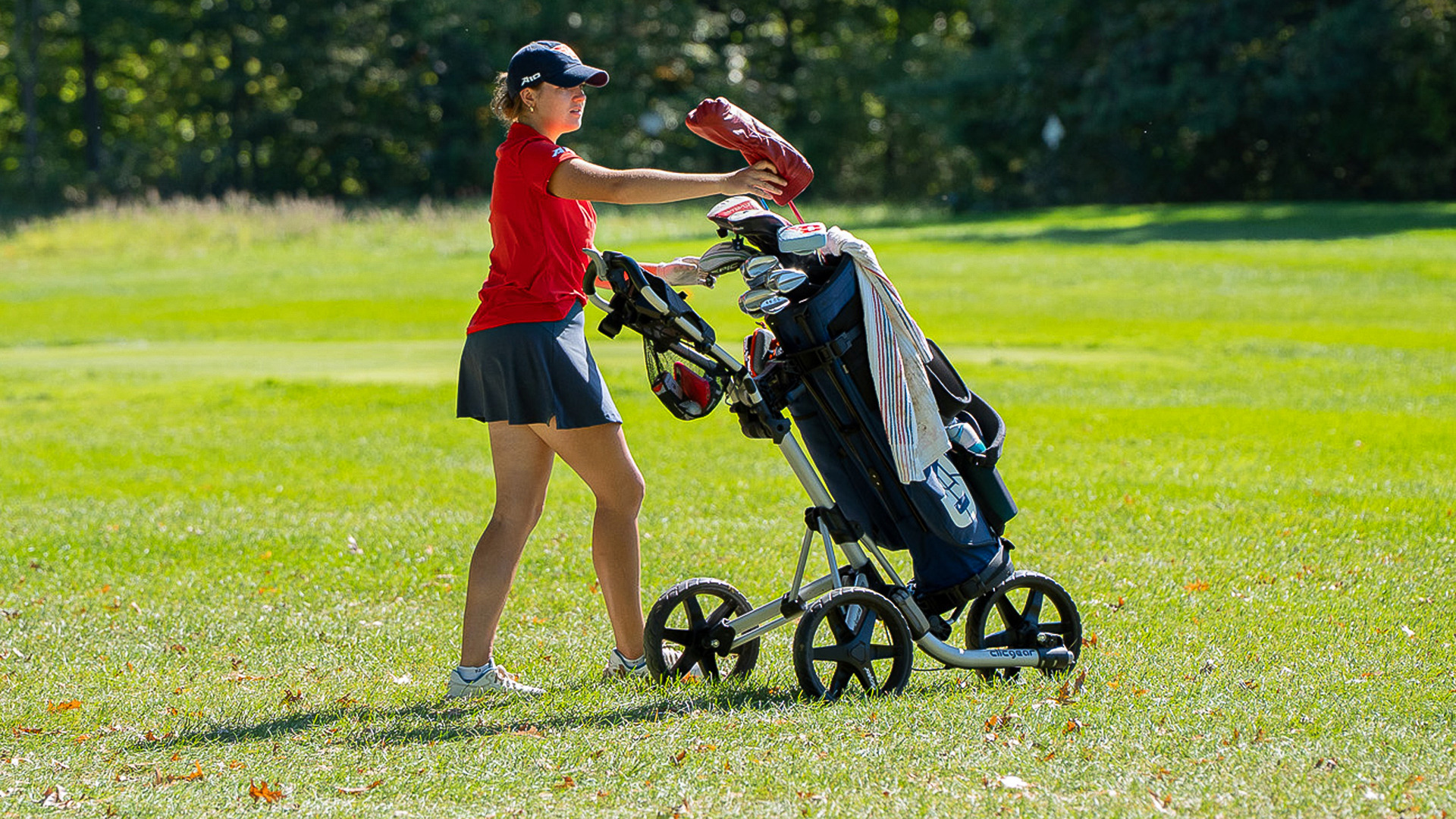 A women's golfer selecting her club at the Butler Invite