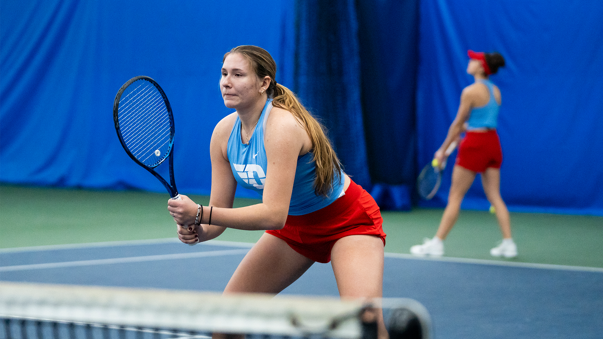 Natalie Osiecki stands ready at the net for teammate Montserrat Sierra to serve.