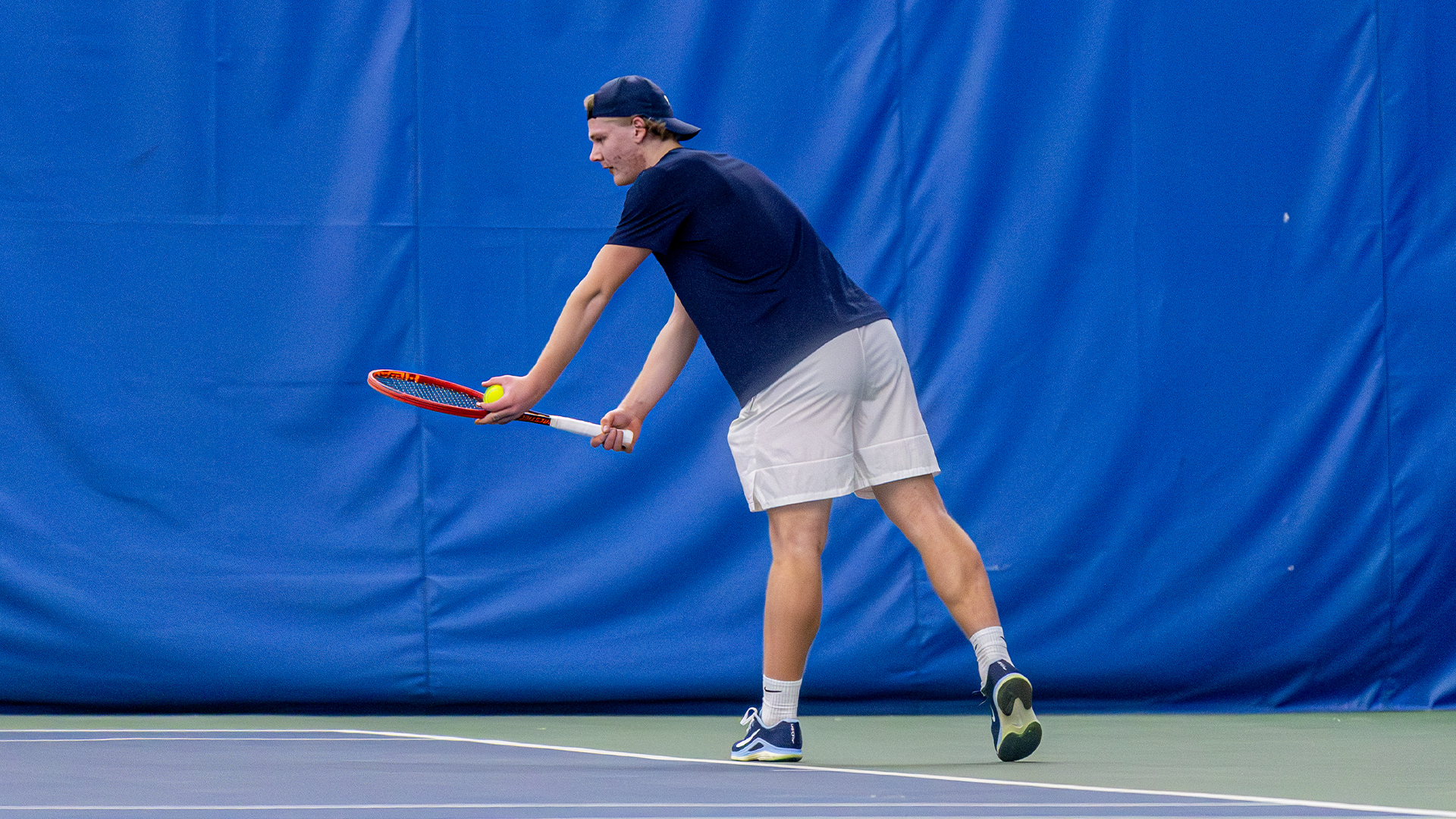 Sturle Skigelstrand holds his racquet and a tennis ball in front of him, preparing to serve.
