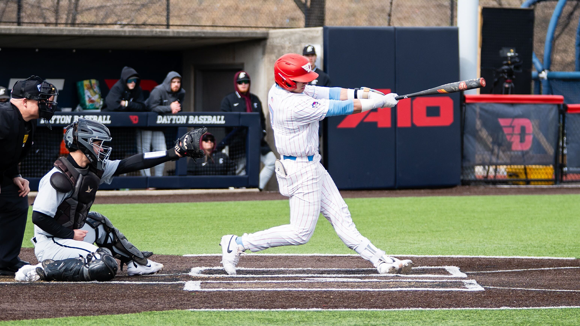 Jason Bello swings his bat, arms extended through his swing.