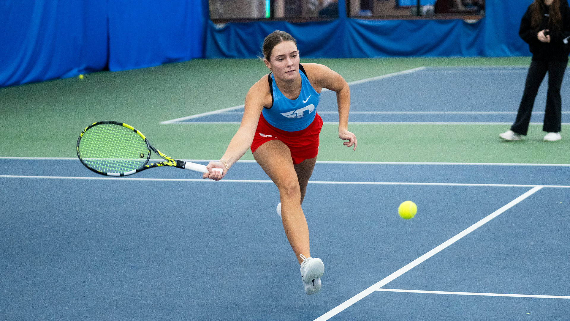 Mallory Hitchcock lunges towards the camera to hit the ball.