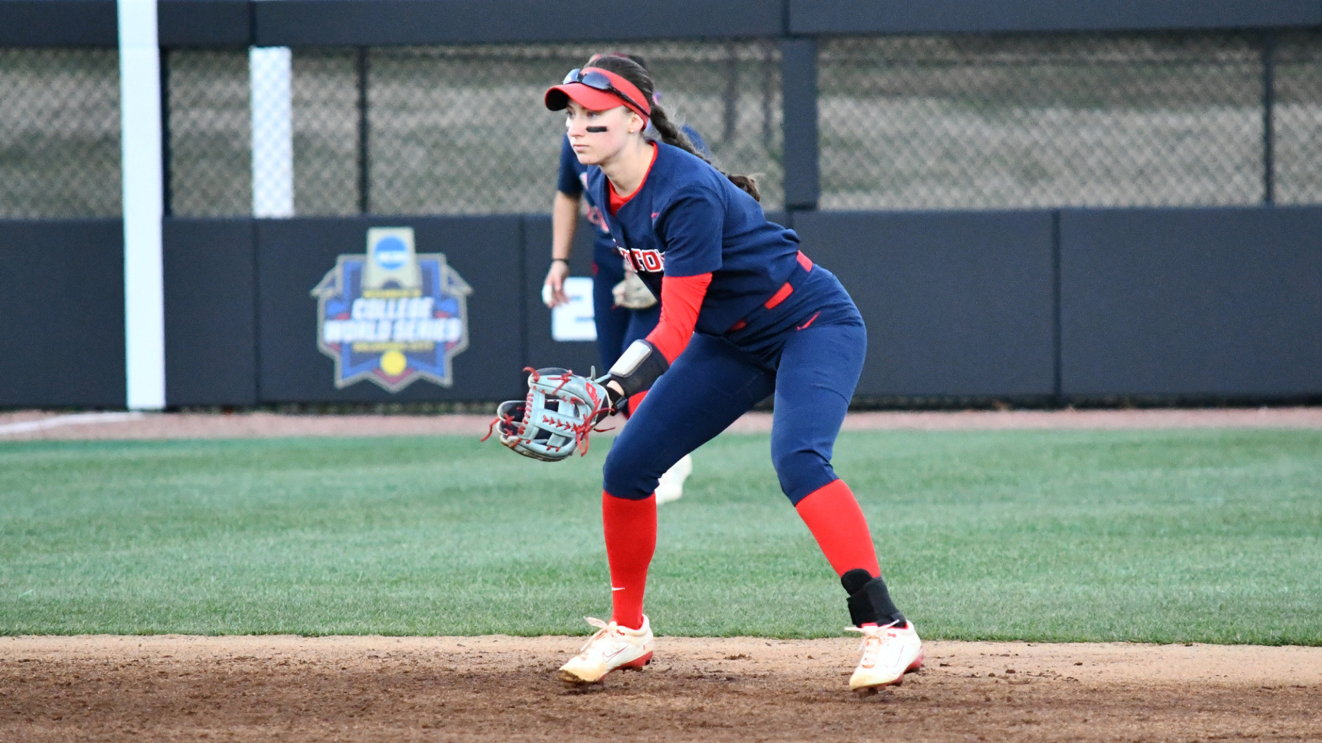 Softball's #2 Kirnan Bailey, wearing a blue Dayton uniform, is in a defensive stance at short stop in a game at Kentucky