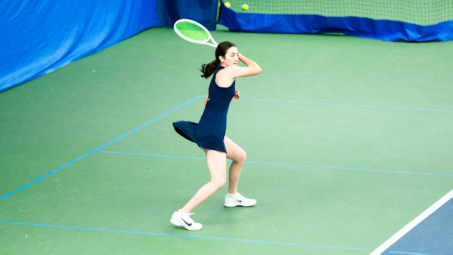 Haley Klein follows through her swing, swinging her racquet from right to left.