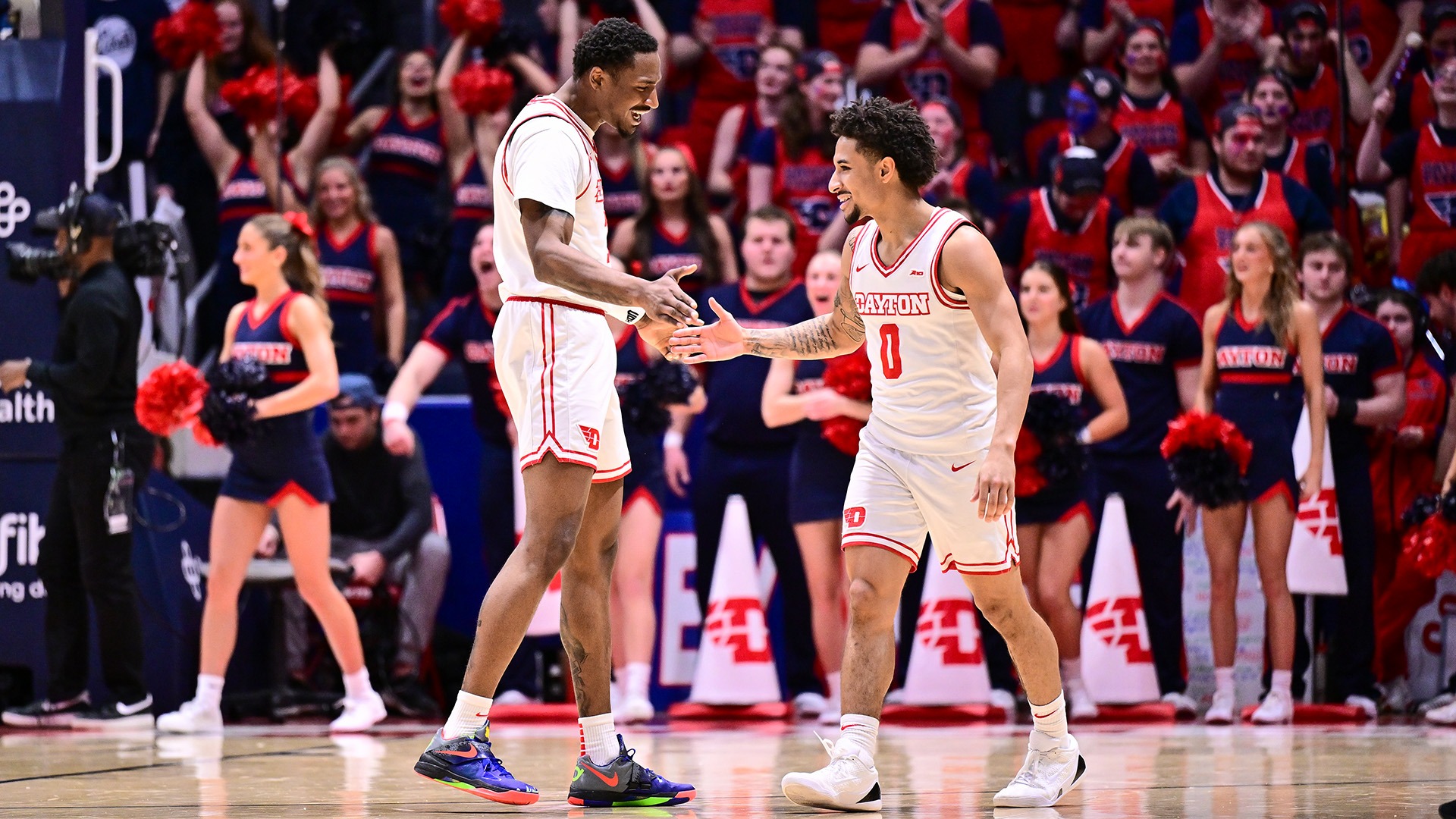Dayton men's basketball players Keonte Jones (left) and Javon Bennett (right) five after a flurry of baskets scored against St. Bonaventure.