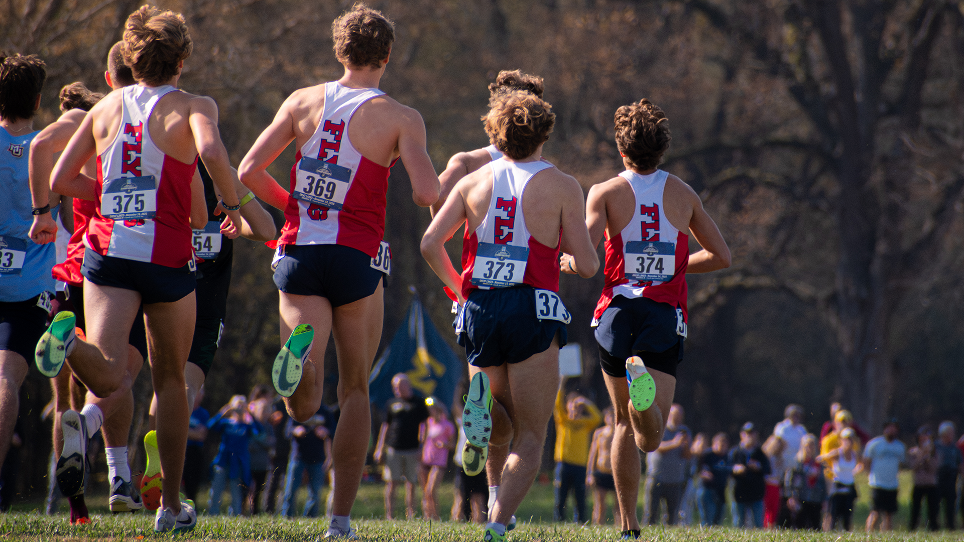 A group of UD cross country runners run away from the camera