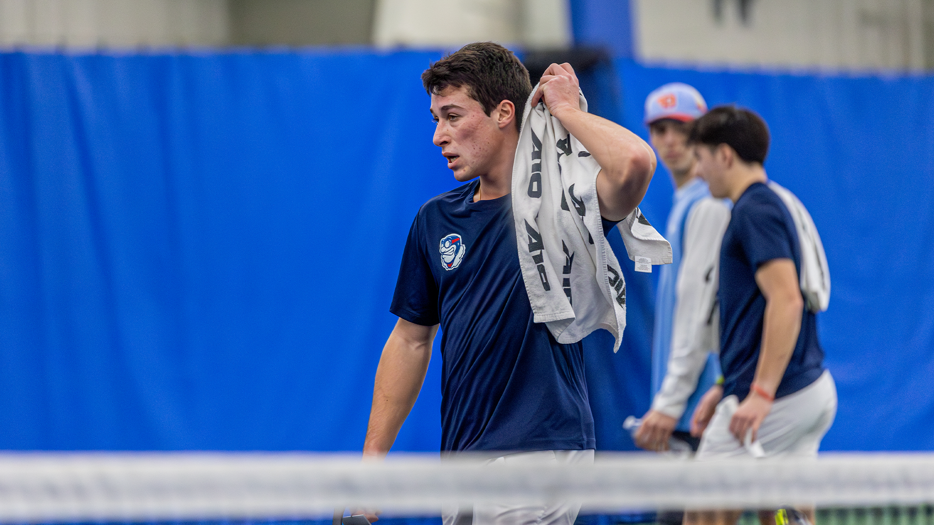 Mikkel Zinder drapes a white towel with the A-10 logo over his shoulder after a match.
