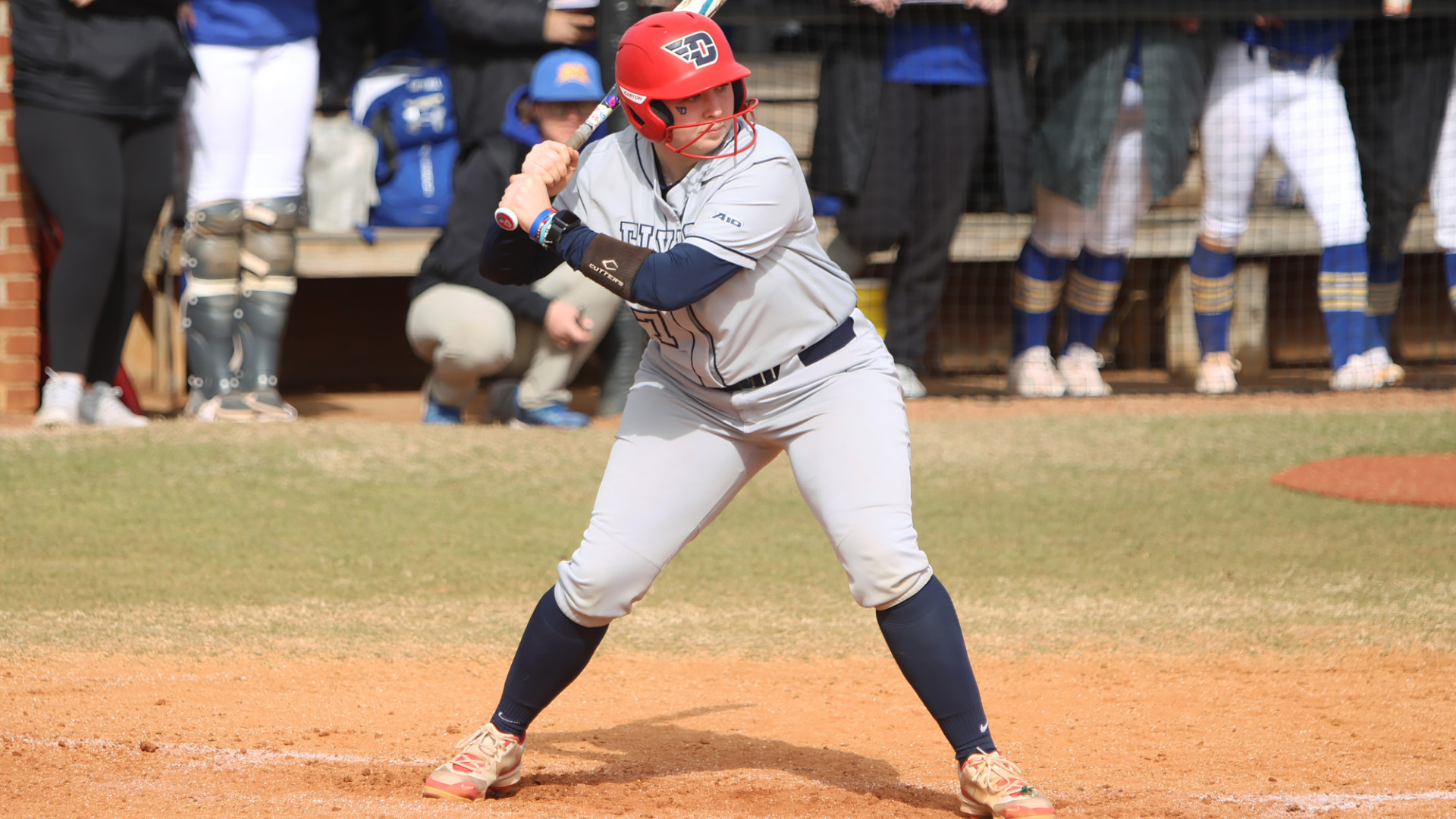Softball's Deirdre Flaherty, wearing a gray Dayton uniform with the number 17 and a red batting helmet, stands in the batter's box with her bat on her shoulder waiting for a pitch