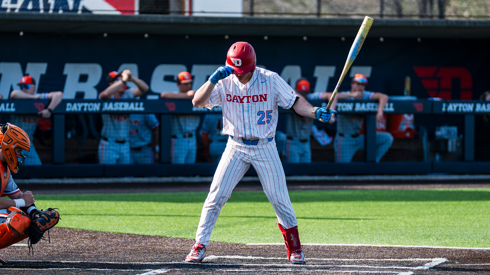 Grayson Carpenter grabs his helmet and flips his bat before stepping into the batter's box.