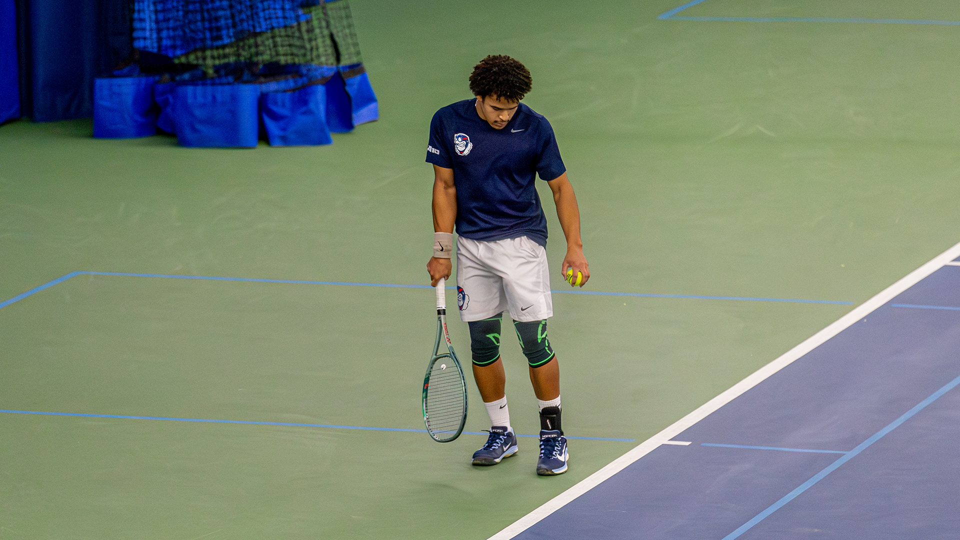 Kaia Mendibe bounces a ball at the ground before serving.
