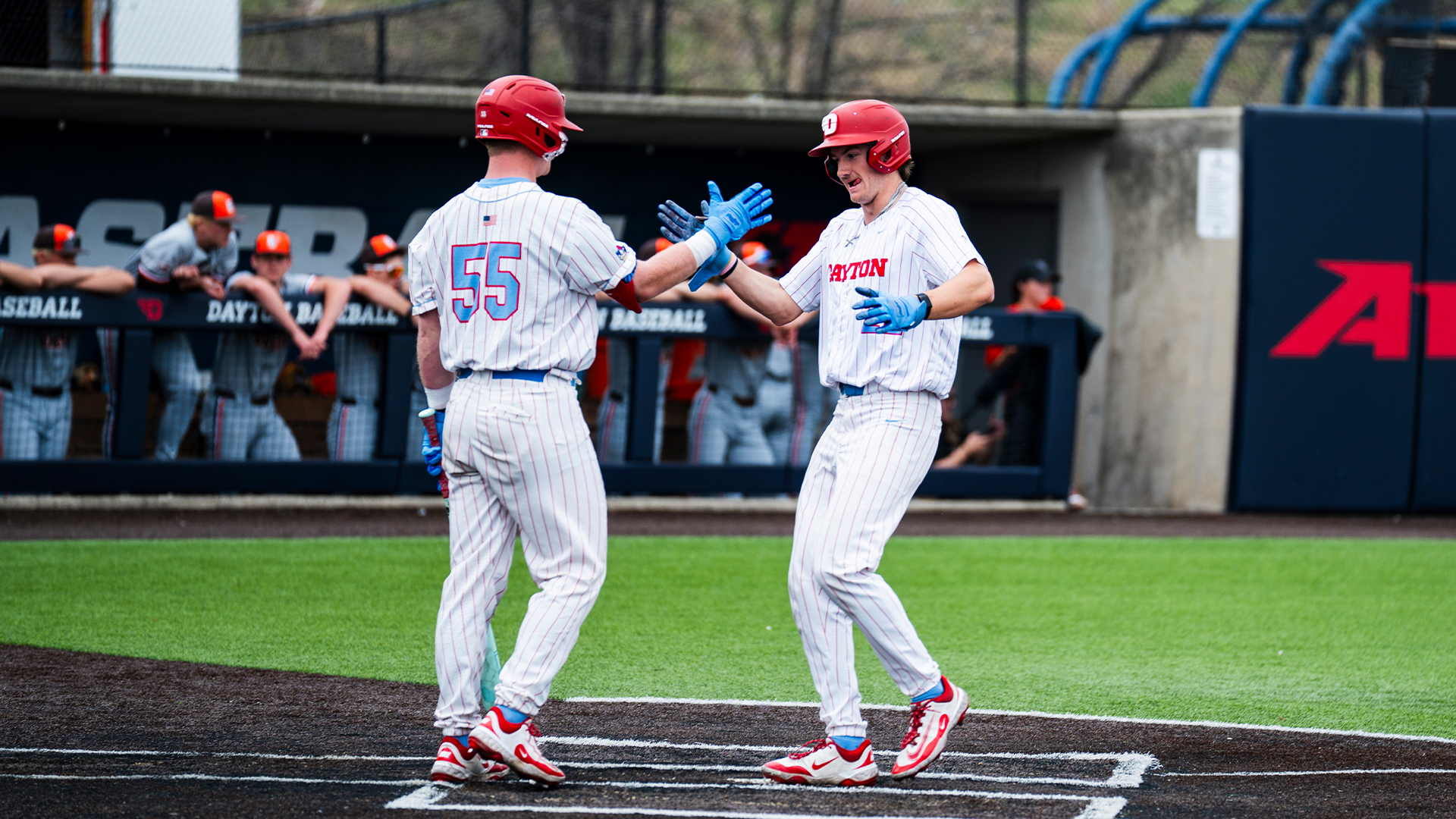Ryan MacDougall and Colin Lynch high five at home plate.