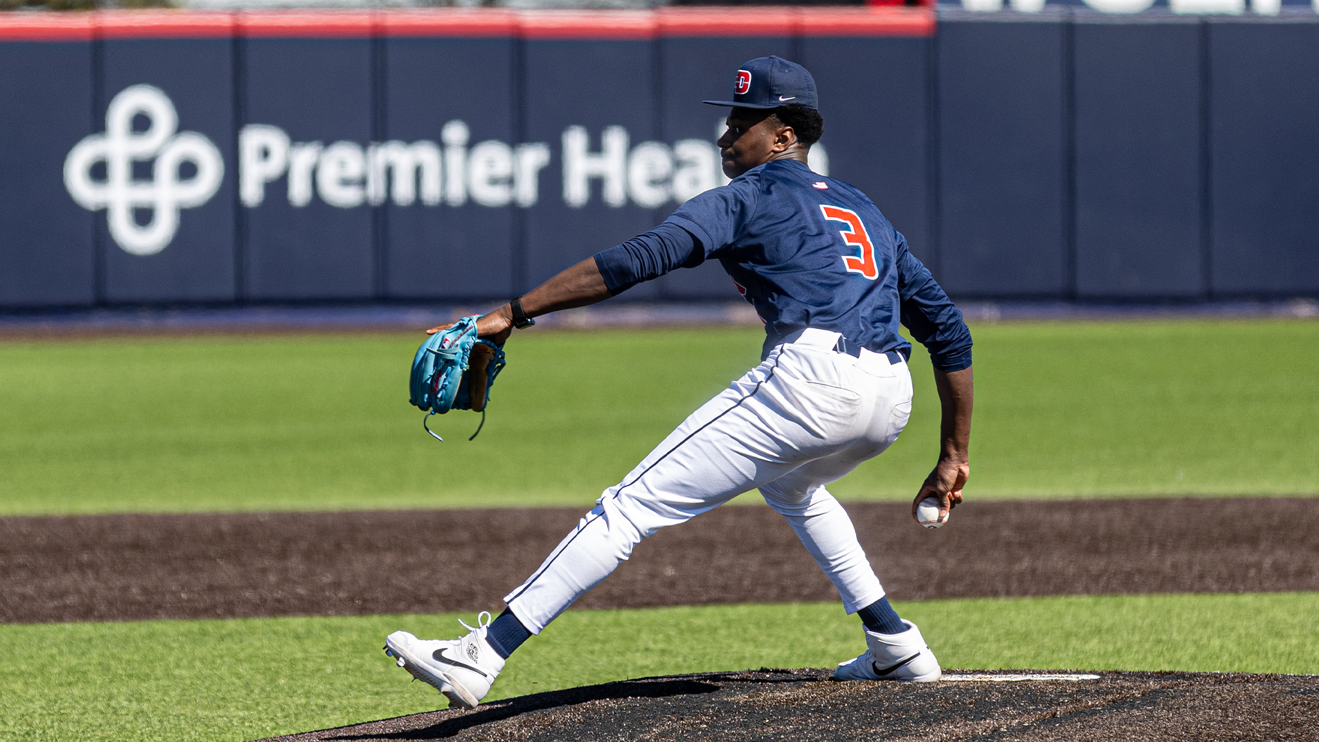 Jon Whiteside pitches the ball. His right hand is down low as he winds up to throw.
