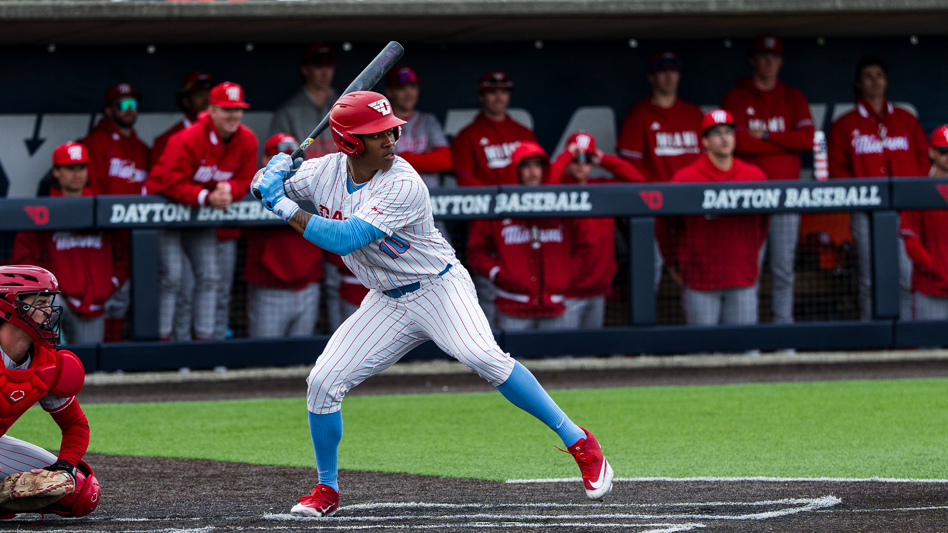 Michael Smith Jr., standing in the right-handed batter's box, winds up to swing his bat.