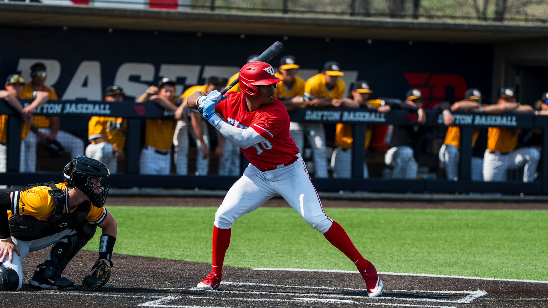 Michael Smith Jr., wearing a red helmet and jersey and white pants, stands in the batter's box, ready to swing.