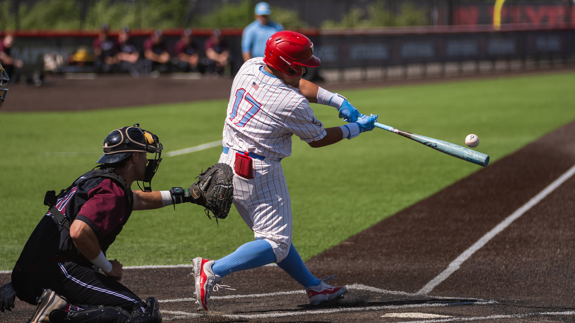 Dyrenson Wouters, wearing a red helmet, white pinstripe uniform and blue socks, swing his bat and makes contact with the ball.