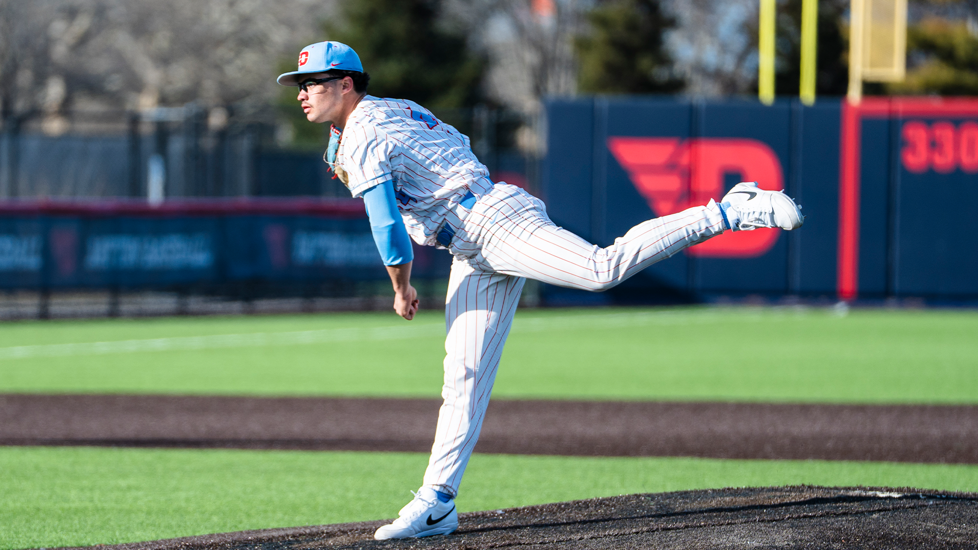 John Delgado pitches the ball, his right leg in the air behind him.