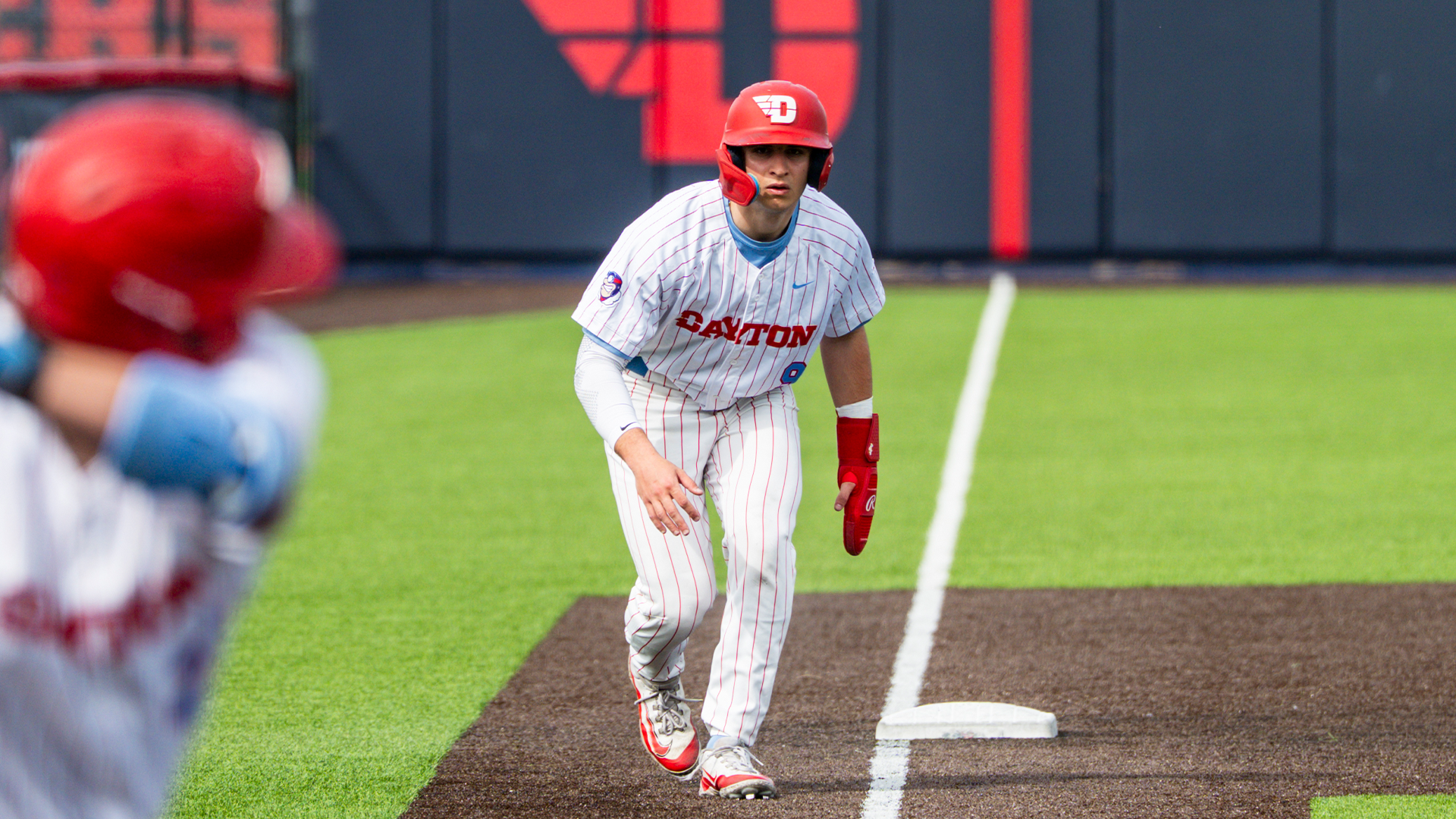 Mike Lucarelli leads off at third base, hunched over and ready to run.