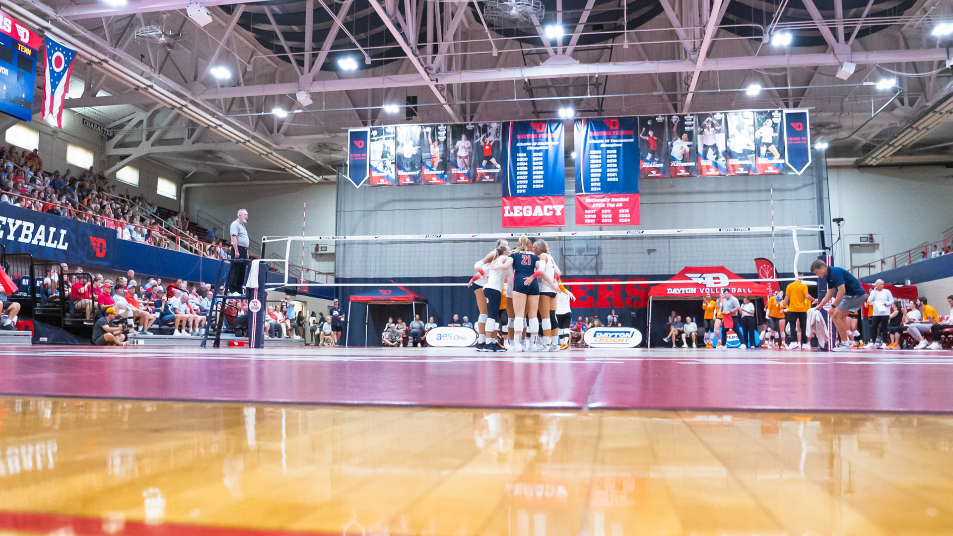 A view of the Frericks Center from the floor. Players huddle on the court after a rally.